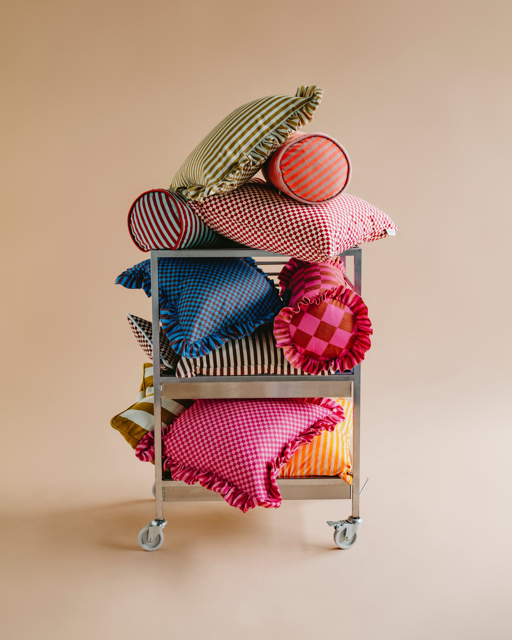 Cart with colorful pillows on a beige background