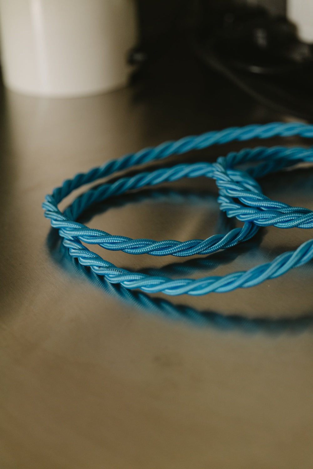 Coiled blue cable on a reflective surface